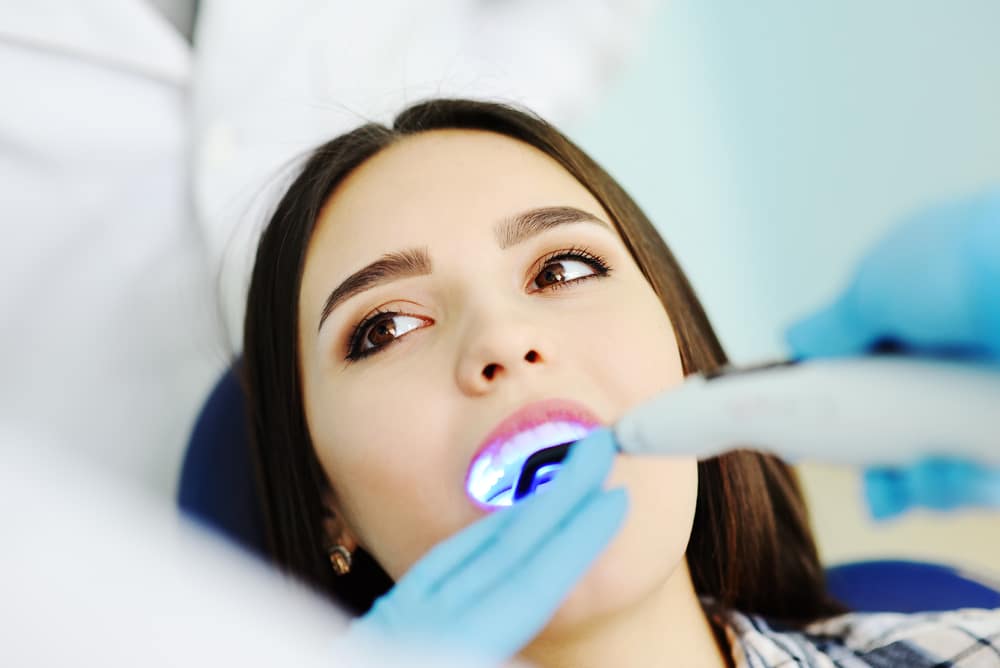 Woman having laser dental work done to fix silver fillings