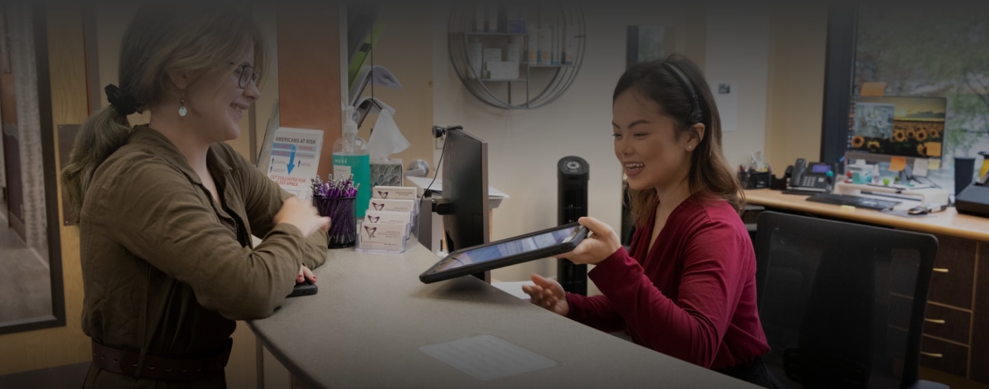 Friendly front desk staff at Health Centered Dentistry helps a patient.