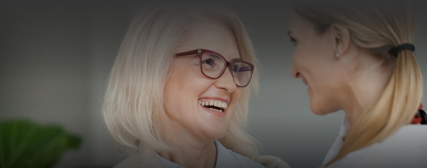 Women laugh together showing healthy teeth from dental services at Health Centered Dentistry