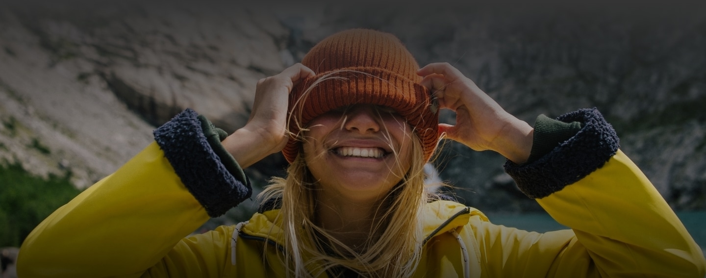 Woman smiling outdoors in Alaska showing healthy teeth from dental services at Health Centered Dentistry