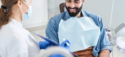 Man talking with his dentist about poor oral health issues