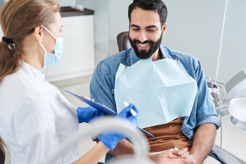 Man talking with his dentist about poor oral health issues