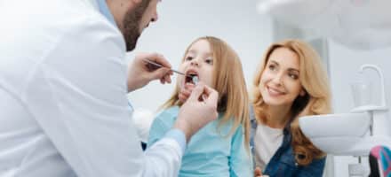 Family dentist examining a child's mouth.