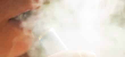 Woman vaping and affecting her dental health